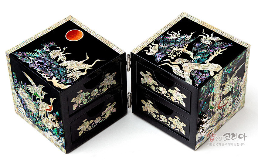 [텍스트: 샵오브코리아 대한민국의 품격까지 전합니다.] 흑색 옻칠 바탕에 자개 상감 기법으로 송학도, 소나무, 구름, 해를 표현한 사각 쌍합 장식함 구성
