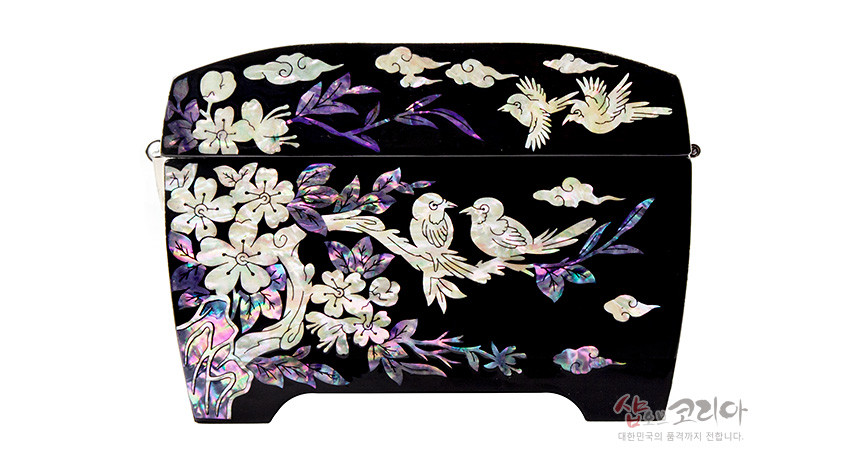 [텍스트: 샵오브코리아 대한민국의 품격까지 전합니다.] 흑색 옻칠 바탕 위 자개 상감 기법으로 화조와 구름, 꽃과 잎을 섬세하게 표현한 곡선형 보석함 디자인