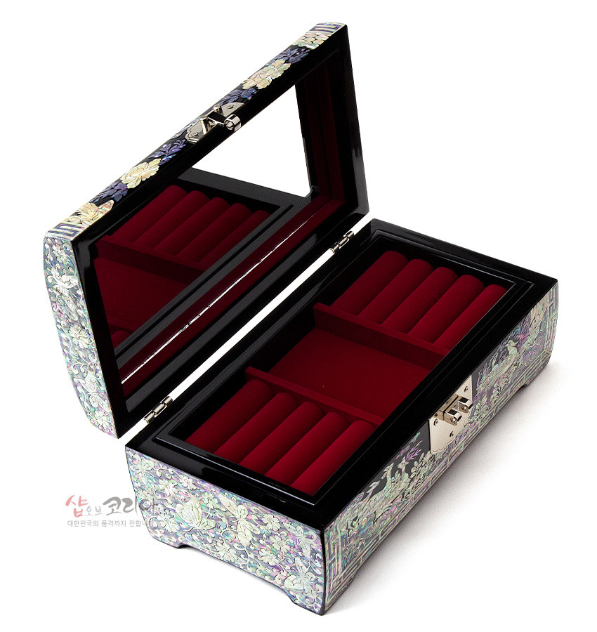 [텍스트: 샵오브코리아 대한민국의 혼과 멋이 전하는] 흑색 옻칠 위 자개 상감으로 송학과 꽃문양을 표현한 보석함, 뚜껑 내부 거울과 붉은 비단 느낌의 칸막이 수납 구조 특징