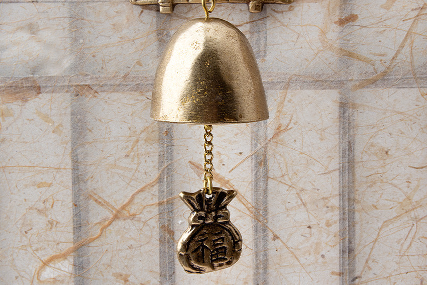 [텍스트: 福] 금속 재질 반구형 문종과 사슬로 연결된 복주머니 장식, 황동빛 광택과 한지 느낌 배경의 조화로운 구성