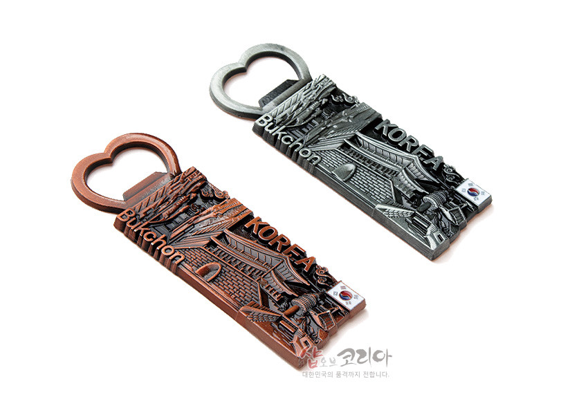 [텍스트: Bukchon, KOREA] 금속 재질의 하트형 오프너 손잡이와 북촌 한옥마을 입체 부조, 태극기 장식이 더해진 투톤 메모 자석 디자인
