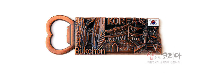 [텍스트: KOREA, Bukchon] 동색 금속 재질에 북촌 한옥과 성곽 문양을 입체 부조로 표현하고, 태극기 장식과 하트형 오프너 손잡이가 더해진 메모 자석형 오프너 디자인