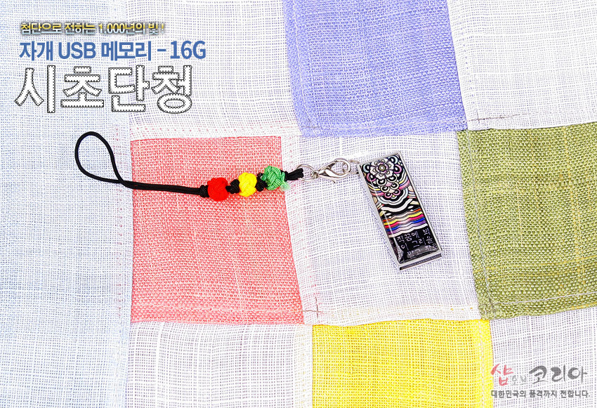[텍스트: 첨단으로 전하는 1,000년의 빛! 자개 USB 메모리 - 16G 시조단청 / 한국의 빛깔] 금속 테두리에 자개 상감된 단청 문양 직사각형 USB와 오방색 매듭 장식 스트랩, 다색 모시 조각보 배경 구성