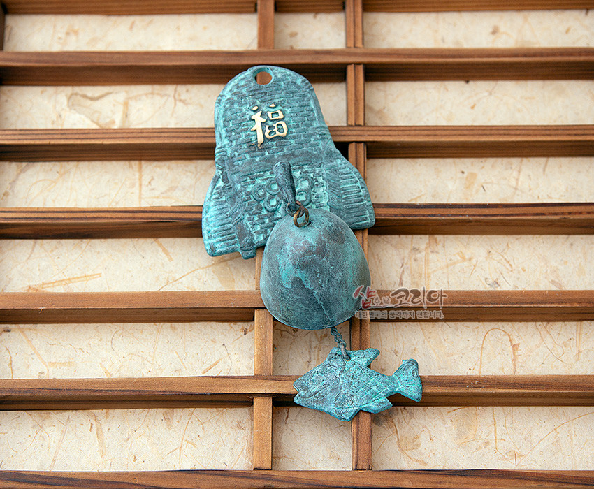 [텍스트: 福, 샵오브코리아 한국 문화의 품격까지 전합니다.] 청동 재질 산화 청록색 마감의 전통 문종, 상단 복자와 물결 문양, 하단 반구형 종과 물고기 장식 구성