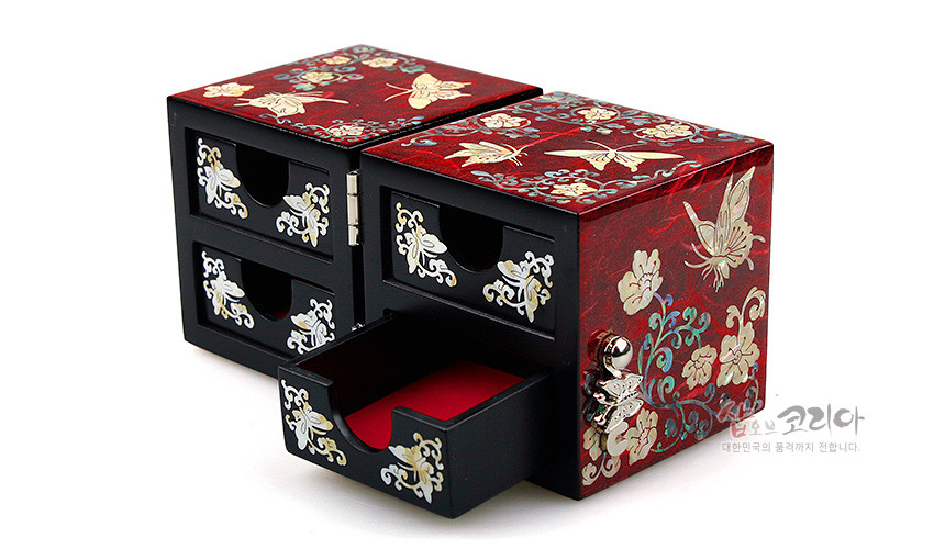 [텍스트: 샵오브코리아 대한민국의 품격까지 전합니다.] 적색 옻칠 바탕 위 자개 상감 나비와 당초문 장식, 흑색 한지 서랍과 내부 붉은 안감이 대비되는 쌍합 보석함 이미지 설명