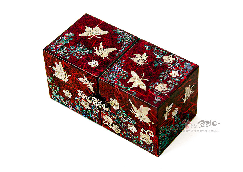 [텍스트: 샵오브코리아 대한민국의 품격까지 전합니다.] 붉은 옻칠 한지 위 자개 상감 기법으로 나비와 당초문, 꽃문양을 섬세하게 장식한 직사각형 쌍합 보석함 이미지