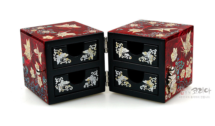 [텍스트: 샵오브코리아 대한민국의 품격까지 전합니다.] 적색 옻칠 바탕 위 자개 상감 나비·당초·연화문 장식, 흑색 서랍면에 백색 자개 문양 배치된 쌍합 보석함 이미지