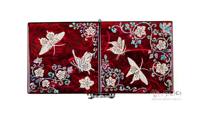 [텍스트: 샵오브코리아 대한민국의 품격까지 전합니다.] 적색 옻칠 바탕 위 자개 상감으로 표현된 나비와 당초 화문이 대칭 구성을 이룬 한지 나전칠기 쌍합 보석함 이미지 설명