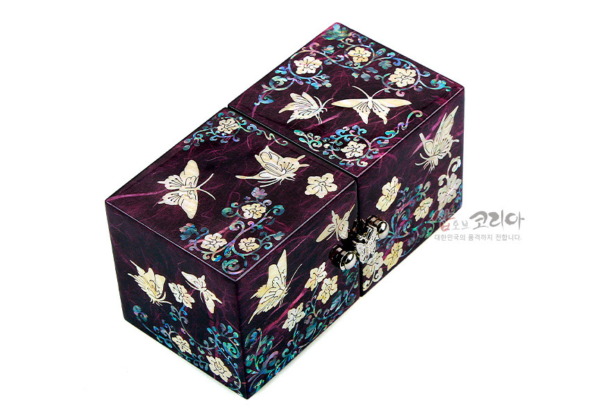 [텍스트: 샵오브코리아 대한민국의 품격까지 전합니다.] 자색 옻칠 한지 바탕 위 자개 상감으로 당초넝쿨과 나비, 꽃 문양을 섬세하게 장식한 사각 쌍합 보석함 모습
