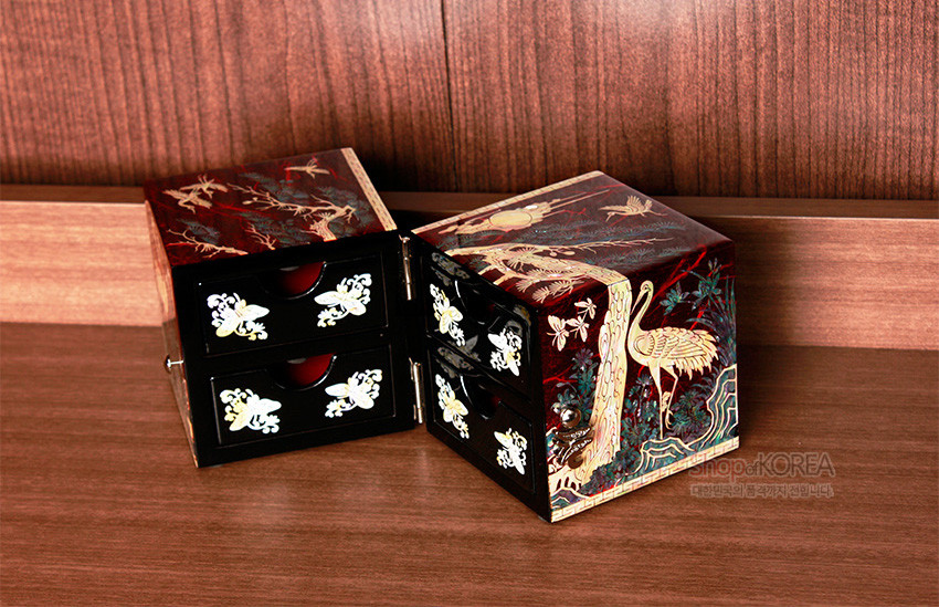 [텍스트: shopofKOREA 대한민국의 전통 공예품입니다] 붉은 옻칠 바탕 위 자개 상감으로 학과 소나무, 해와 구름을 표현한 한지 쌍합, 흑색 서랍면의 나비·꽃 자개 장식 특징