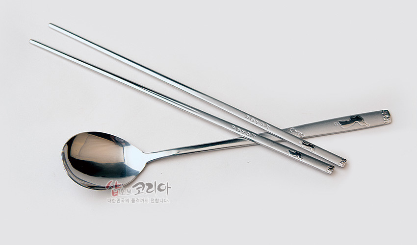 [텍스트: 샵오브코리아 대한민국의 품격까지 전합니다] 은색 금속 재질의 숟가락과 젓가락, 손잡이 부분 한반도 지도 양각 장식이 돋보이는 심플한 수저 세트 이미지