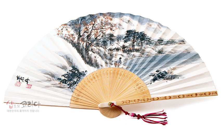 [텍스트: 샵오브코리아 대한민국의 품격까지 전합니다.] 대나무 합죽선 구조 위 한지에 수묵채색 겨울 산수화, 붉은 매듭술과 자개 장식이 더해진 전통 접부채 이미지 설명