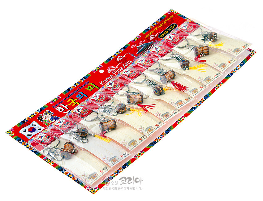 [텍스트: Korea traditional beauty, 한국의 미, Korea Fine Arts, HAND MADE] 금속 고리와 목재 질감 장구·북 미니어처, 태극 문양 채색 및 빨강·노랑 술 장식이 어우러진 열쇠고리 세트 이미지 설명