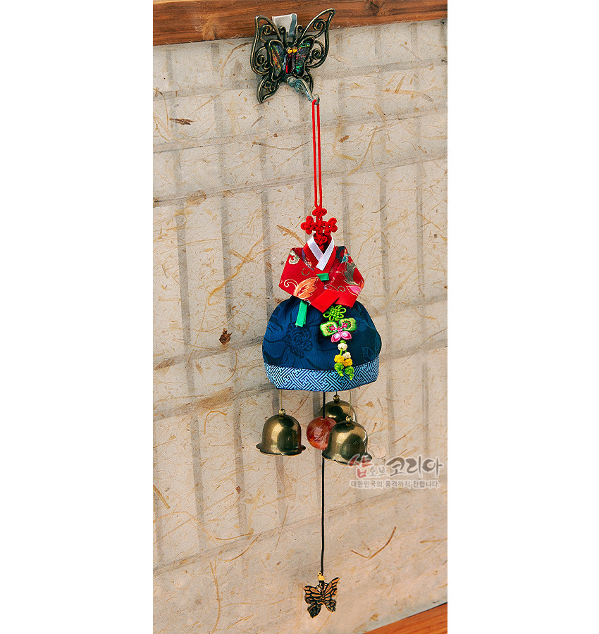 [텍스트: 샵오브코리아 대한민국의 공기거치 전문] 금속 나비 장식 고리에 적색 비단 저고리와 청색 치마 한복 형태, 자수와 매듭 기법, 하단 금속 방울과 나비 추 장식 문종 이미지설명