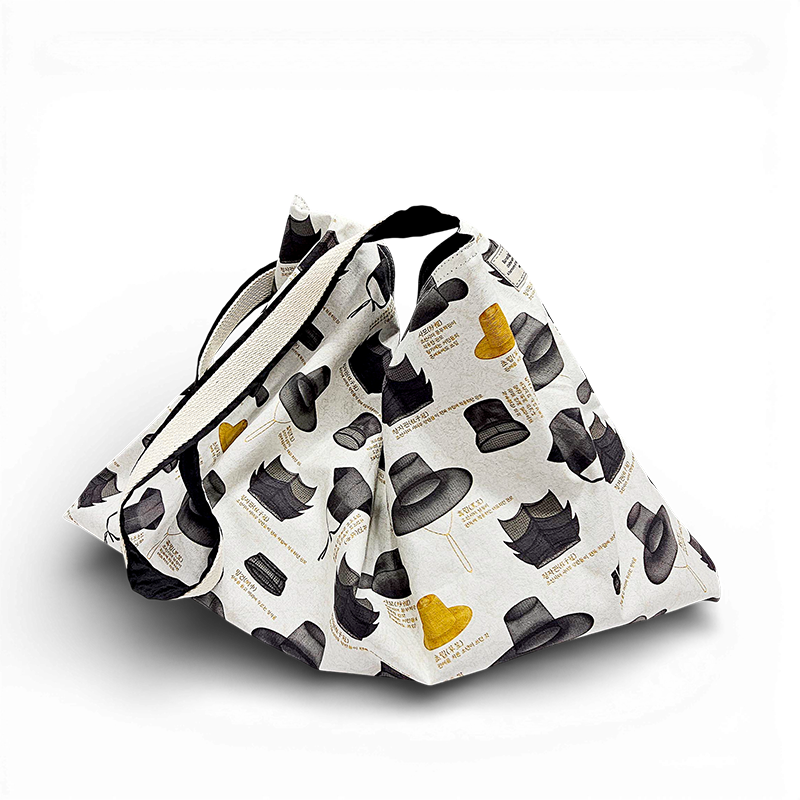 [텍스트: 세종 12년, 조선시대 각종 갓 이름 및 설명 등 영문·한글 혼합 문구] 아이보리 캔버스 소재 위 전통 갓과 모자 일러스트 패턴, 흑색·황색 대비 색감의 에코백 디자인