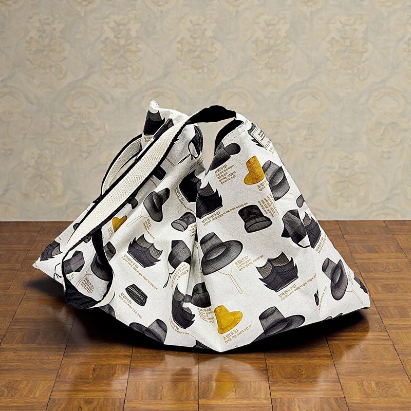 [텍스트: 중절모 / 상투 모자 / 승려 모자 등] 다양한 형태의 한국 전통 갓과 모자 일러스트가 인쇄된 에코백, 흑색·황색 대비가 돋보이는 패턴 디자인