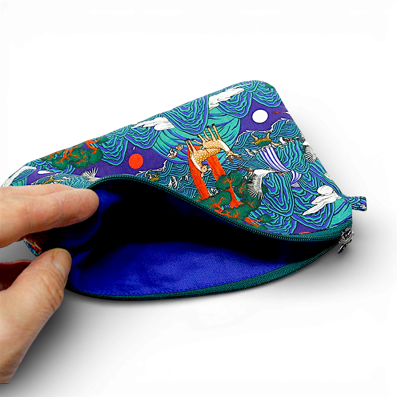 텍스트 없음] 청록과 보라색 비단 느낌 원단에 일월오봉도와 십장생 문양이 인쇄된 파우치, 내부 선명한 남색 안감 처리된 디자인