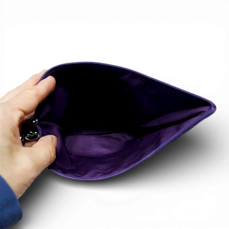 어두운 보라색 천 소재 내부가 보이는 지퍼 파우치, 부드러운 안감 마감과 심플한 직사각형 구조 강조된 모습