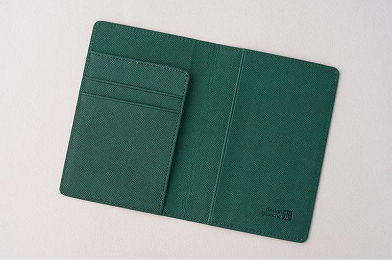 [텍스트: design gauche] 에메랄드 그린 합성가죽 재질, 사선 패턴 엠보싱 처리와 카드 수납 포켓이 구성된 여권지갑 내부 디자인