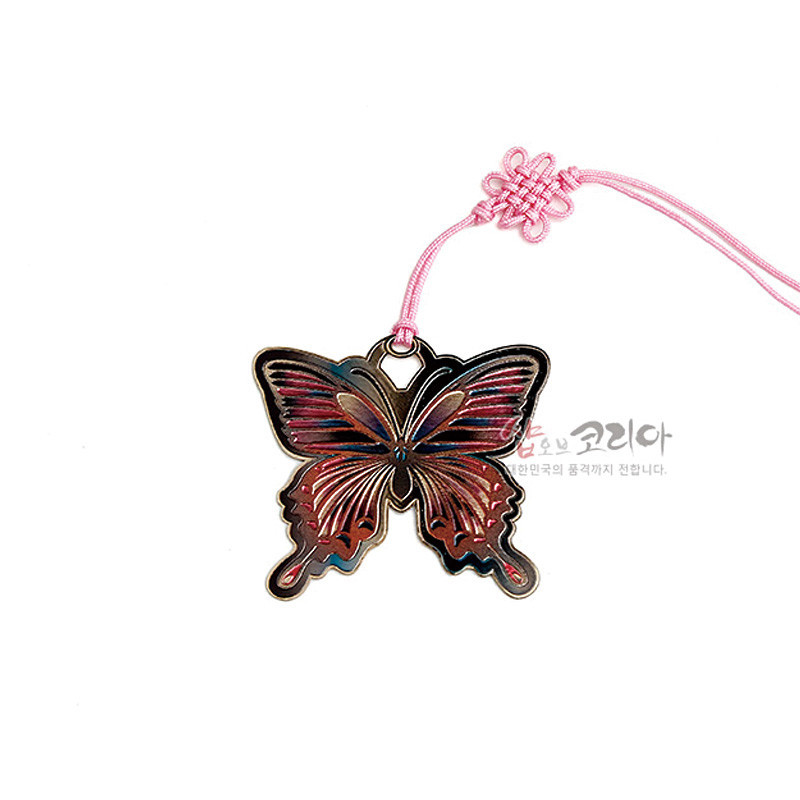 금장 금속으로 제작된 나비 모양 책갈피와 분홍색 전통 매듭 장식 끈 연결 장식. 금장 금속으로 제작된 나비 모양 책갈피와 분홍색 전통 매듭 장식 끈 연결 장식.