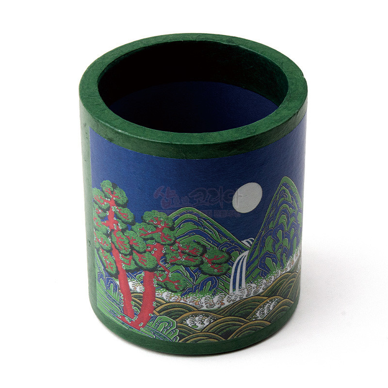 짙은 청록 배경 위에 일월오봉도 산수와 소나무, 폭포 문양이 인쇄된 원통형 펜꽂이.