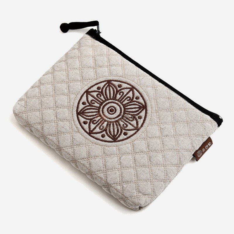 연한 백색 누빔 원단 위에 갈색 고구려 수막새 원형 문양 자수 장식이 돋보이는 지퍼 파우치.