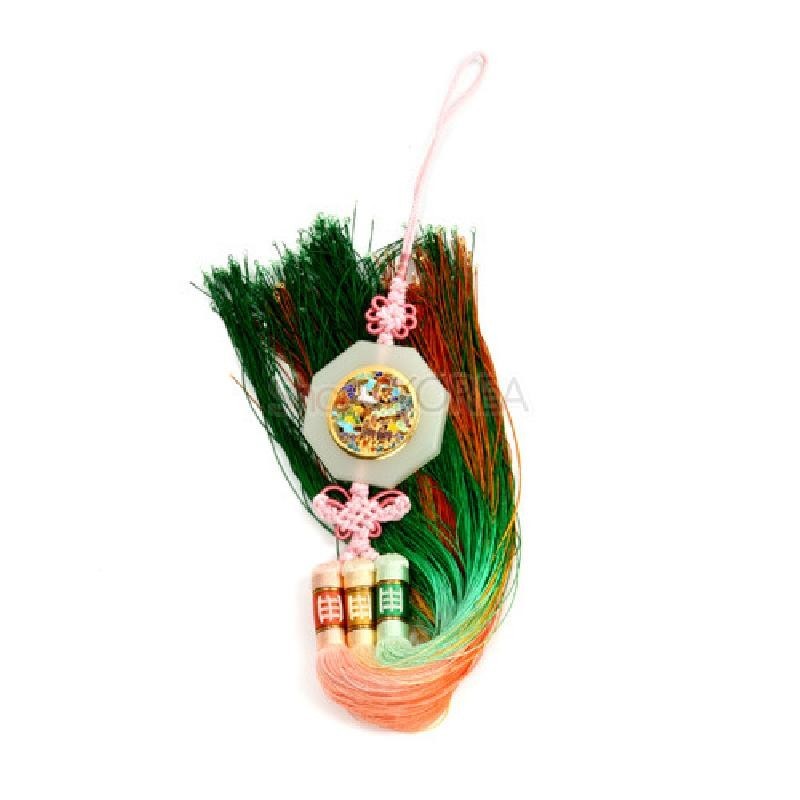 옥칠 장식 중앙에 자개 상감 원형 문양이 들어간 팔각 장식과 분홍 매듭, 녹색·주황 그라데이션 술이 조화를 이루는 3봉 노리개.