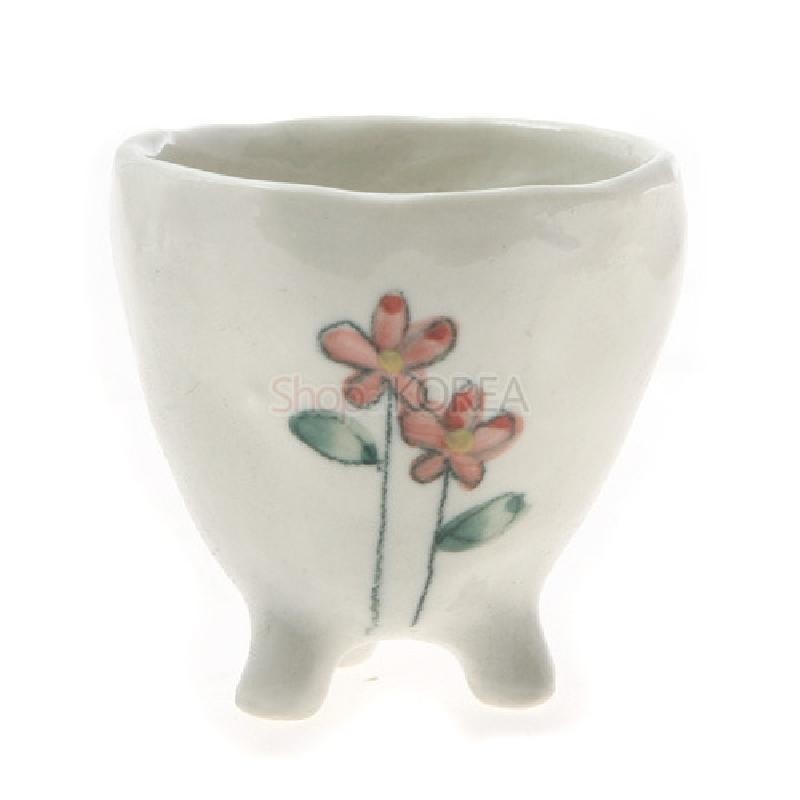 백색 도자 재질, 세 다리 형태의 잔 몸체에 붉은빛 야생화와 녹색 잎을 수채화풍으로 그린 소주잔.
