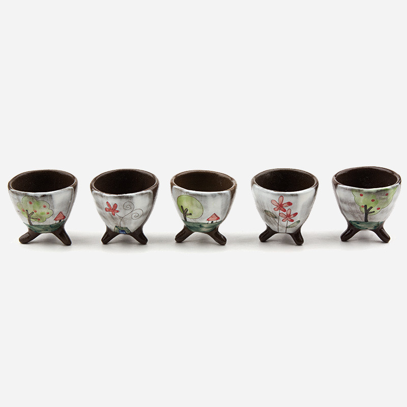갈색 도자기로 제작된 삼각 다리 소주잔에 흰 바탕 위 수채화풍 나무와 꽃, 집 등 야생화 풍경 문양을 그린 세트.