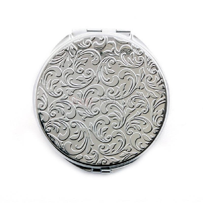 은빛 금속 재질의 원형 손거울로, 표면에 유광과 무광이 어우러진 곡선 식물문 양각이 섬세하게 장식되어 있다.