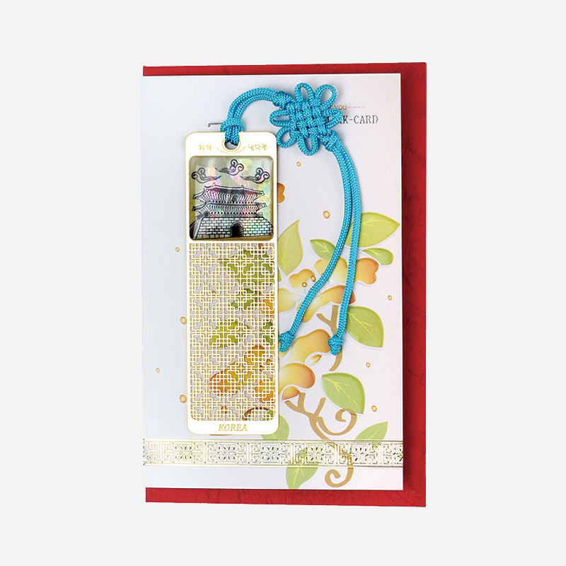 자개로 남대문 전경을 상감하고 금속 위 격자 무늬를 새긴 몸체와 청색 전통 매듭 장식이 조화로운 책갈피.