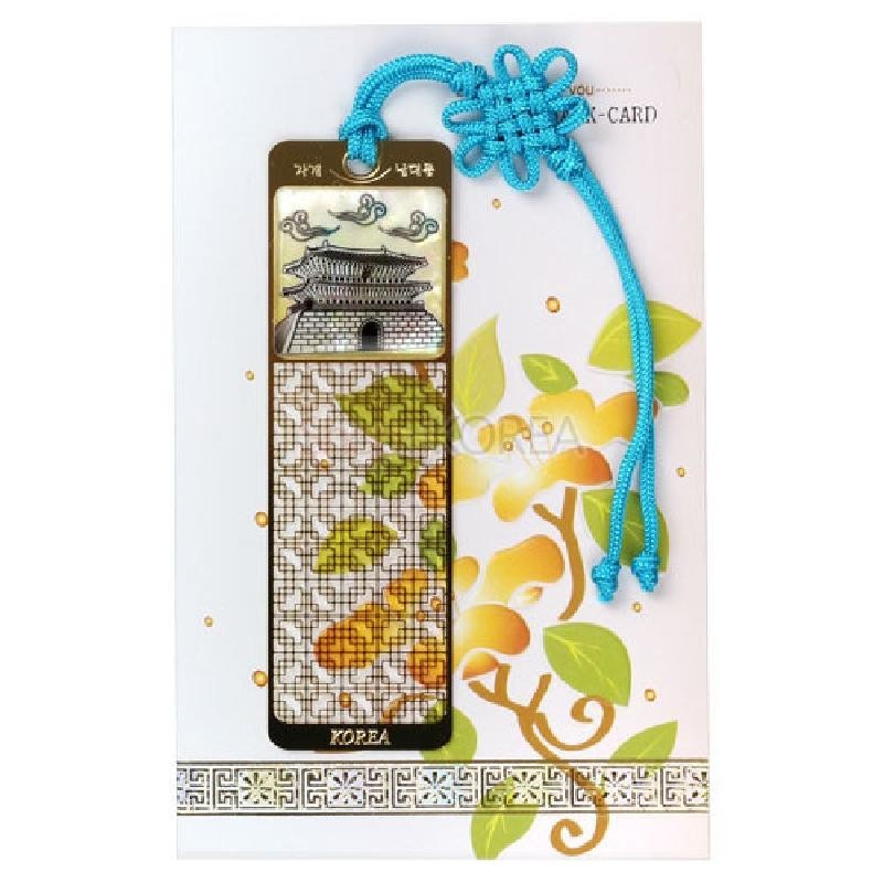 자개 상감으로 남대문과 구름 문양을 표현하고, 단풍잎 무늬와 청색 전통 매듭끈 장식이 있는 금속 책갈피.