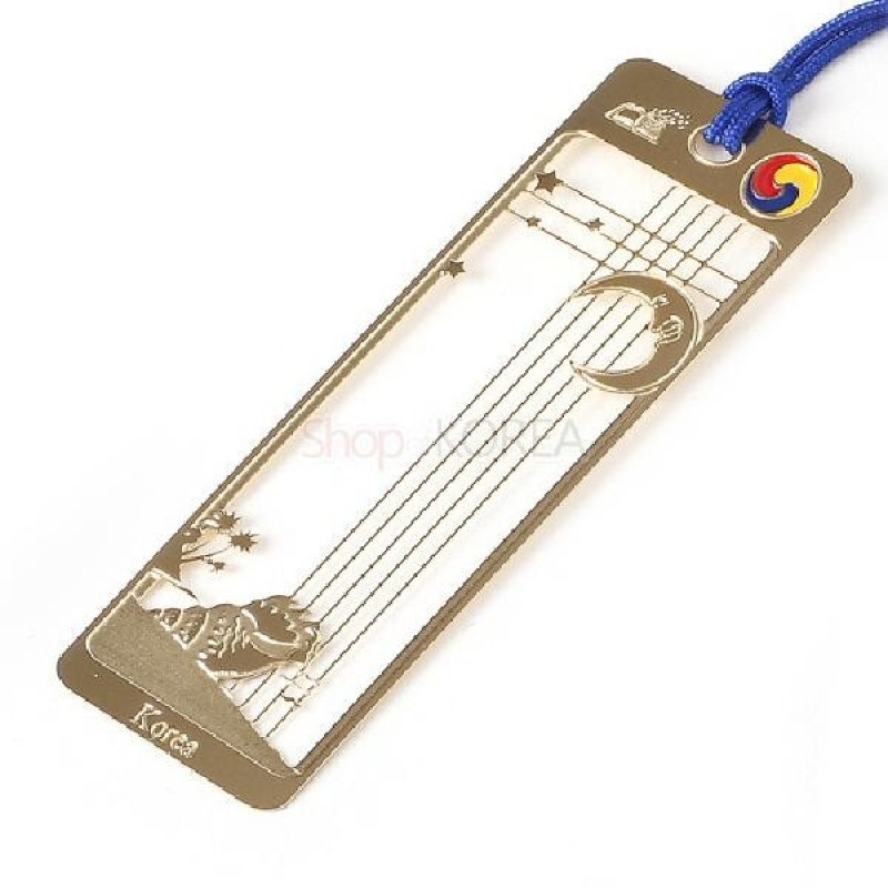 금속 재질 오픈워크 기법으로 표현된 달과 고동, 별 문양이 특징인 금장 책갈피.