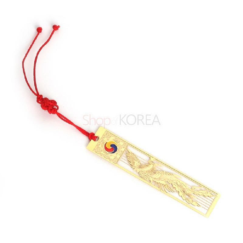 금장 금속으로 제작된 봉황 문양 책갈피와 태극 문양 포인트, 붉은색 전통 매듭 장식의 조화.