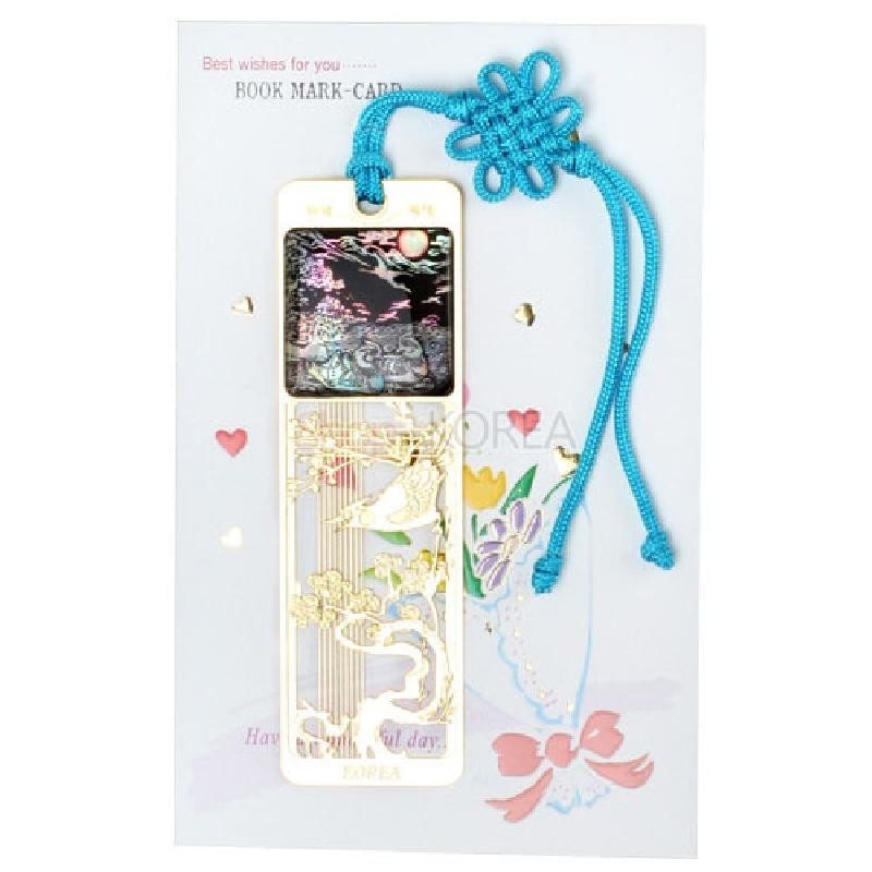 자개 상감 기법으로 표현된 밤하늘과 원앙 문양, 금속 재질의 오픈워크 장식, 청색 매듭 끈이 어우러진 장식 책갈피.