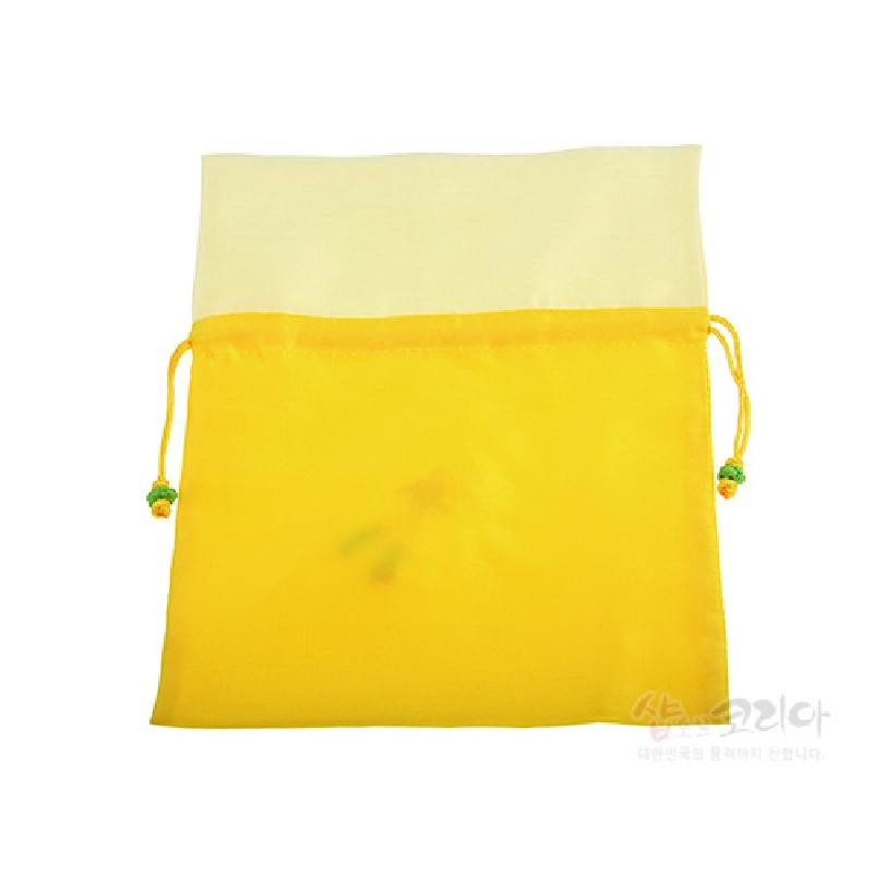 노란 비단 재질의 전통 매듭주머니로, 상단은 옅은 크림색 천으로 배색하고 양쪽 끈 끝에 다색 매듭 장식을 더했다.