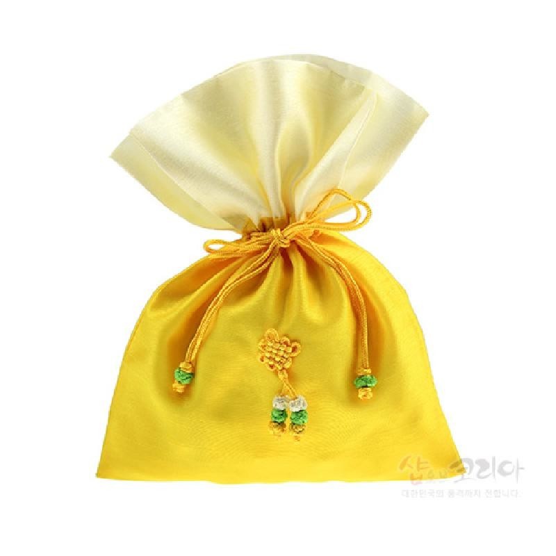 노란 비단 재질의 전통 매듭주머니로, 중앙에 노리개식 매듭과 녹색·흰색 구슬 장식이 달린 끈으로 조이는 구조이다.