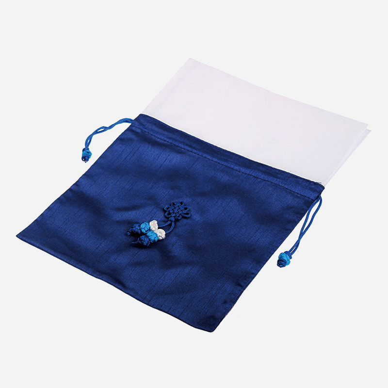 짙은 남색 비단 소재의 전통 매듭주머니로, 중앙에 청색·백색 매듭 장식과 양쪽 끈 조임 장치가 가미된 심플한 디자인이다.