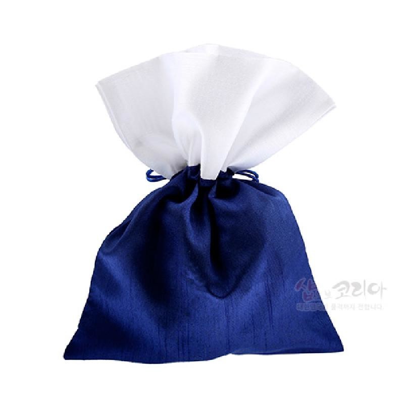 남색 광택 원단과 흰색 천을 사용한 전통 매듭주머니로, 끈으로 여미는 심플한 디자인의 복주머니 형태이다.