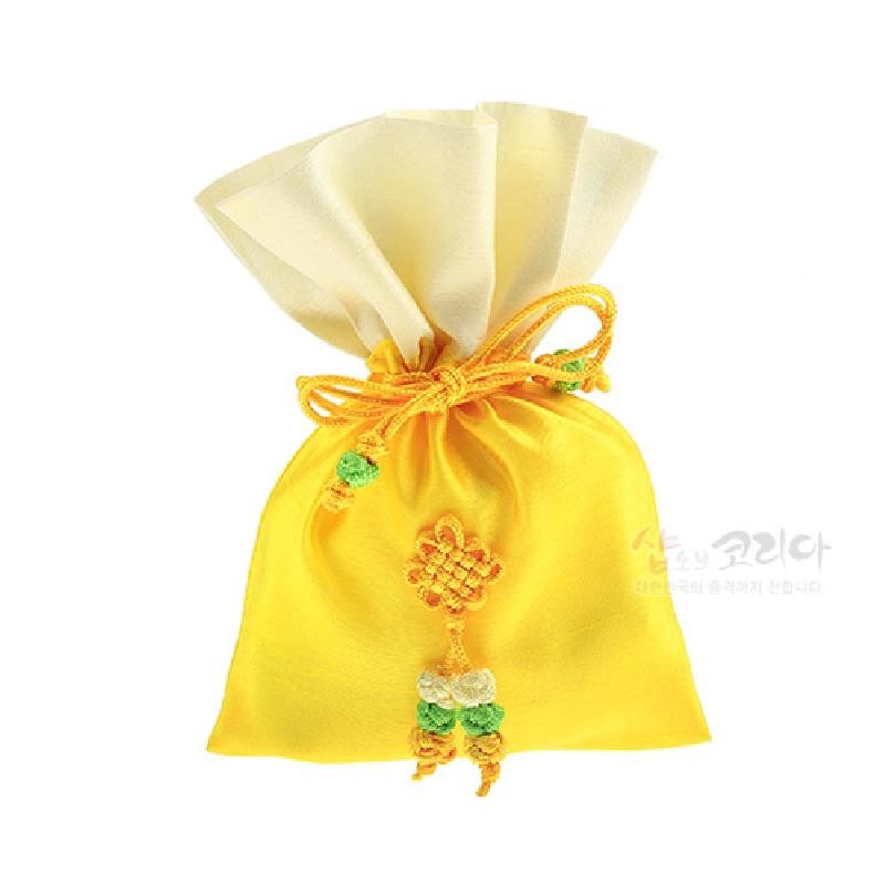 노랑과 아이보리 천으로 만든 전통 매듭주머니로, 중앙에 노랑·초록 매듭 장식과 끈 매듭 장식이 더해진 디자인이다.