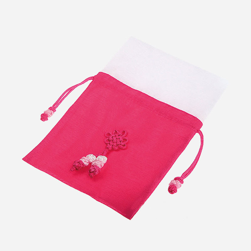 진분홍 색상의 전통 매듭 장식이 돋보이는 천 소재 복주머니로, 끈 조임 방식과 꽃 형태 매듭 문양이 특징이다.