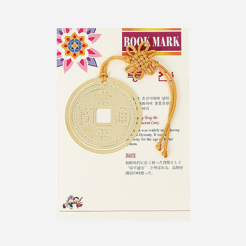 금장 금속 재질의 동전 모양 책갈피와 노란색 전통 매듭 끈 장식이 조화를 이루는 디자인.