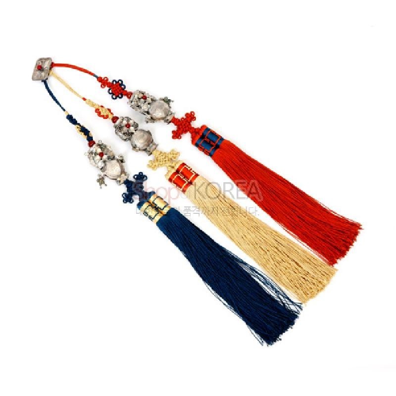 은빛 금속 호랑이 장식과 전통 매듭을 연결한 삼작투호 세트로, 붉은색·황색·남색 술 장식이 조화를 이루는 공예품