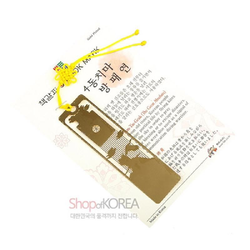 금장 금속 재질의 책갈피로, 방패연과 4동치마 문양을 섬세한 레이저 절삭 기법으로 표현하고 노란 끈 장식을 더했다.