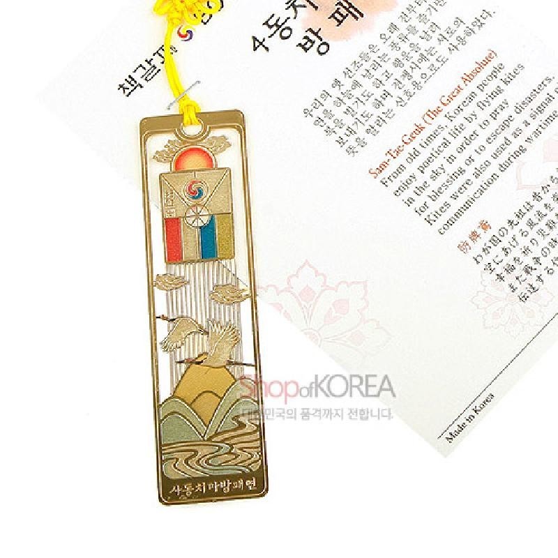 금장 소재의 금속 책갈피로, 사동치마 방패연과 학·산수·물결 문양을 색채 에나멜 기법으로 표현한 전통 디자인 작품.