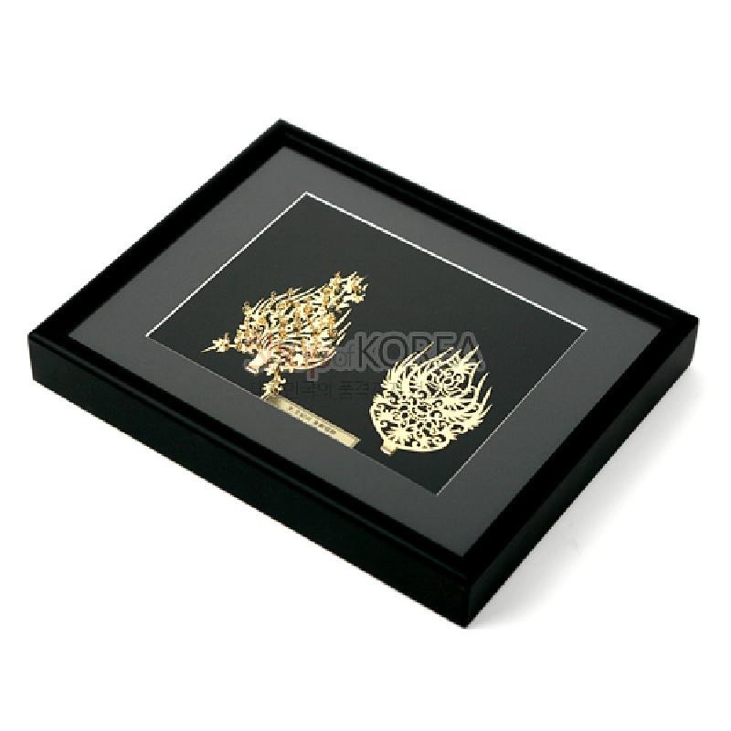 검은 바탕 위 금속 재질로 왕·왕비 금제관식을 정교하게 재현한 금박 장식 액자형 장식품.