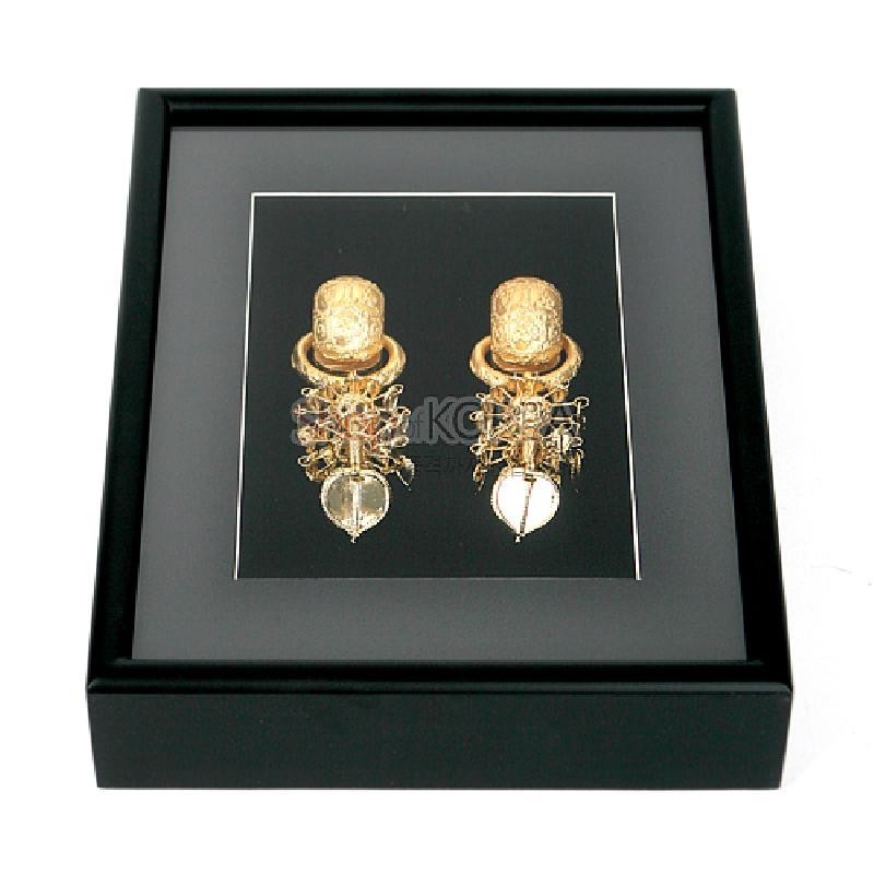 검정 액자 안에 금속 재질의 금제태환이식 두 점을 입체적으로 배치한 장식 액자.