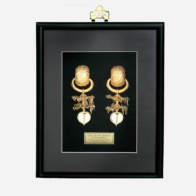흑색 액자 속 금속 금제 태환이식 장식, 섬세한 문양과 입체적 장식추가 특징인 전통 장신구 액자.