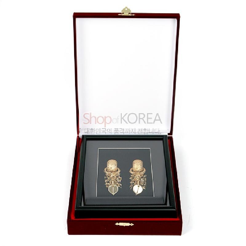 검은 바탕 위 금제 태환이식 두 점을 입체적으로 장식한 액자형 공예품.