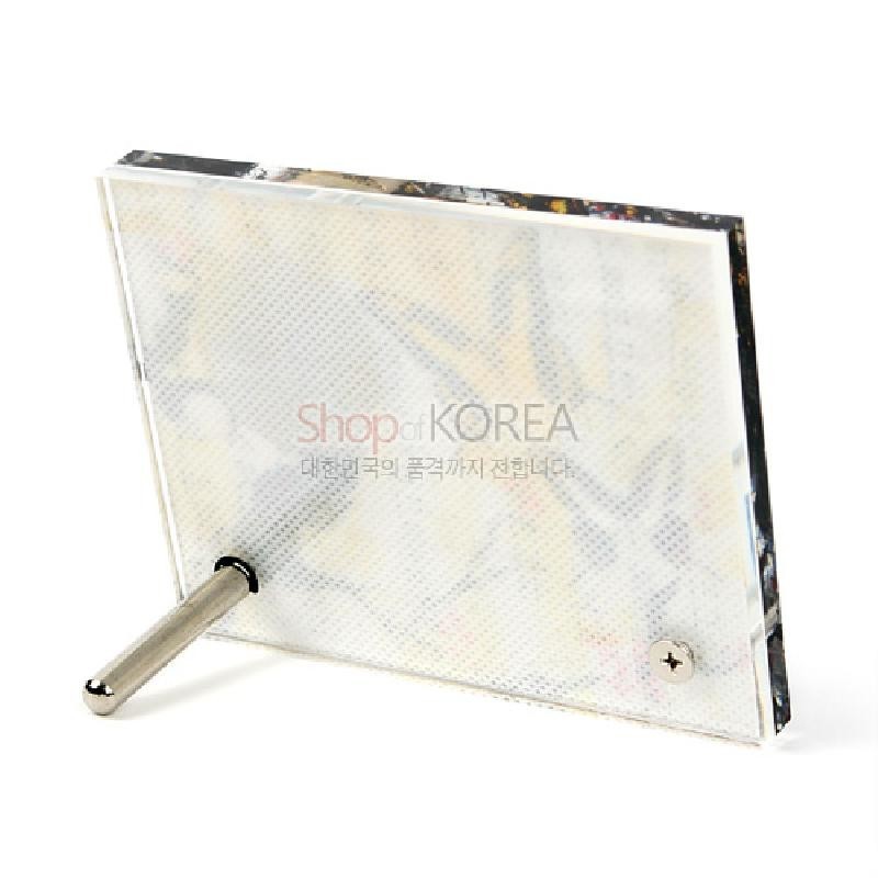 투명 아크릴 소재와 금속 지지대로 구성된 직사각형 탁상용 시계 뒷면 디자인.